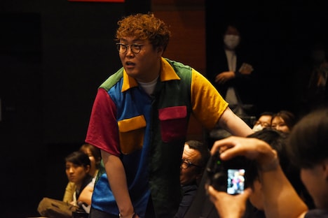 客席のドリンクホルダーに手錠をつながれるマユリカ中谷