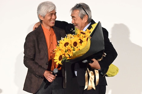 佐藤浩市（左）から花束を受け取る寺尾聰（右）