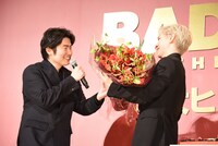 ⻄川達郎（左）から、メンバーカラーの赤で彩られた花束を受け取った豆原一成（右）