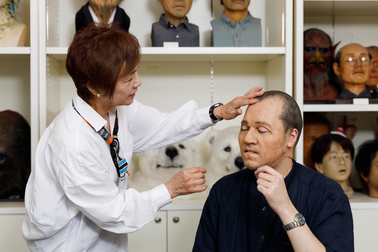 ラバー製のマスクを被ってみたナタリースタッフ（右）