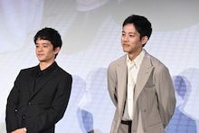 写真をのぞき込む池松壮亮（左）、松坂桃李（右）