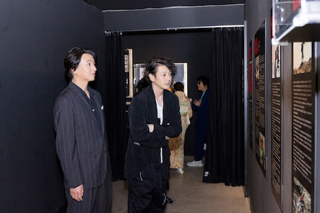 「超クウガ展」キャストプレミア内覧会より、制作資料を見るオダギリジョー（中央）と葛山信吾（左）
