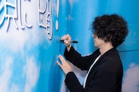 「超クウガ展」キャストプレミア内覧会より、壁紙にサインするオダギリジョー