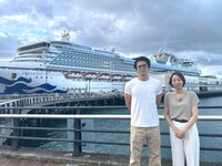 ダイヤモンド・プリンセス号の前に立つ小栗旬（左）、和田祥子さん（右）