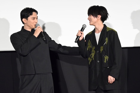 板垣李光人（右）の腕をなで回しながらトークする吉沢亮（左）