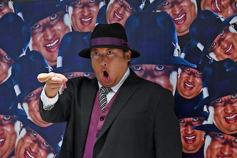 ドラマのビジュアルを背景に記念撮影する秋山竜次