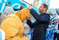 ザ・シングのコスプレをしたファンにサインを書くエボン・モス＝バクラック（右）