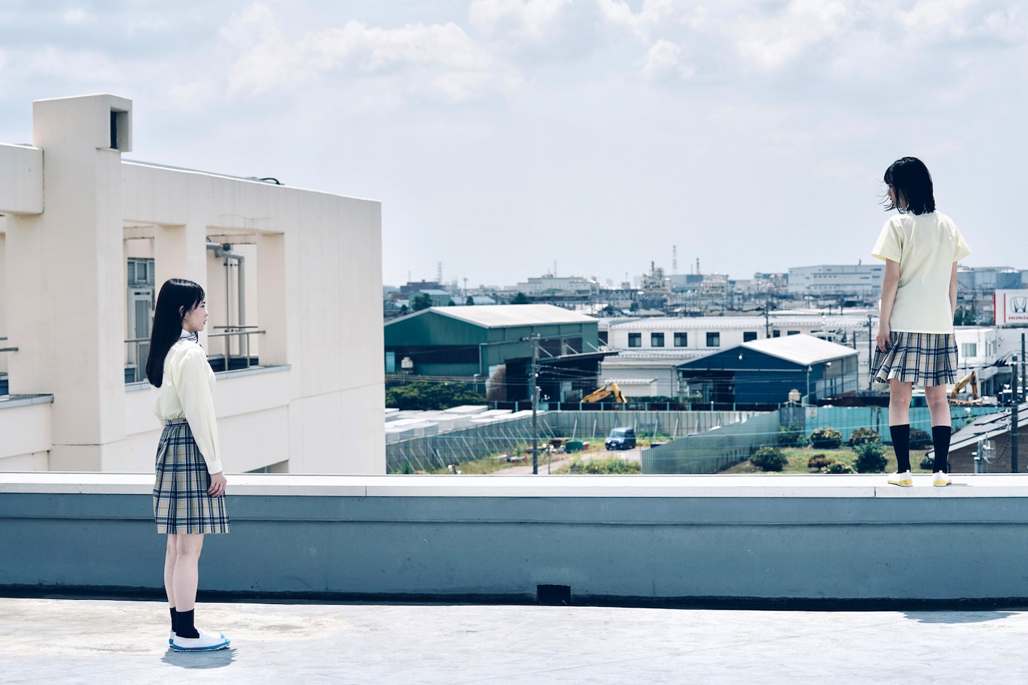 「恋に至る病」新場面写真より、山田杏奈演じる寄河景（左）。屋上から飛び降りようとする女子学生を見つめている