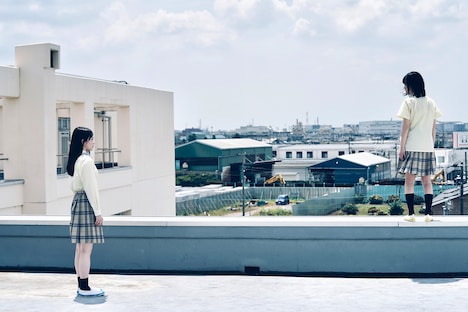 「恋に至る病」新場面写真より、山田杏奈演じる寄河景（左）。屋上から飛び降りようとする女子学生を見つめている