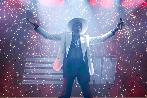 「ランニング・マン」場面写真。コールマン・ドミンゴ演じる番組司会者