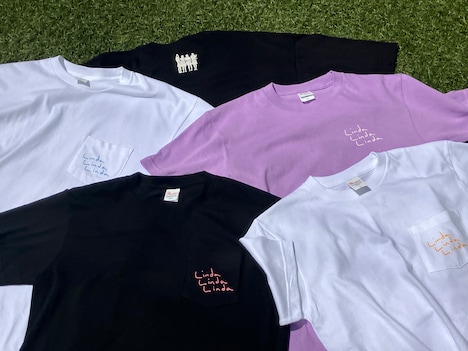 「リンダ リンダ リンダ 4K」公式グッズのTシャツ。白、黒、ライトパープルの3色展開で胸部分には「Linda Linda Linda」と手書き風のロゴがデザインされた