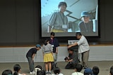 カメラを使って実践してみる監督・是枝裕和(右)、撮影監督・上野千蔵(右から2番目)と子供たち