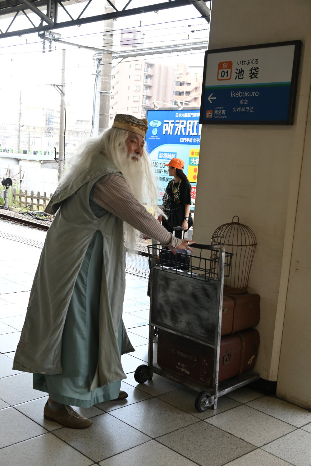 池袋駅のホームに設置された荷物カートで記念撮影をする参加者