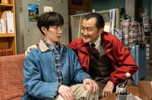 ホラー映画「事故物件ゾク 恐い間取り」場面写真。Snow Man渡辺翔太演じる“事故物件住みますタレント”の桑田ヤヒロ（左）と、吉田鋼太郎演じるヤヒロが所属する芸能事務所社長の藤吉清（右）
