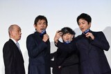 大沢たかお（右）が撮影したオーロラの写真を見るため、スマートフォンをのぞき込む共演者たち