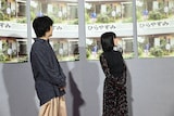 夜ドラ「ひらやすみ」のポスターを眺める岡山天音(左)と森七菜(右)