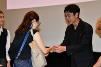 「宝島」東京キャラバンにて、来場者に“名刺”を手渡しする妻夫木聡（右）