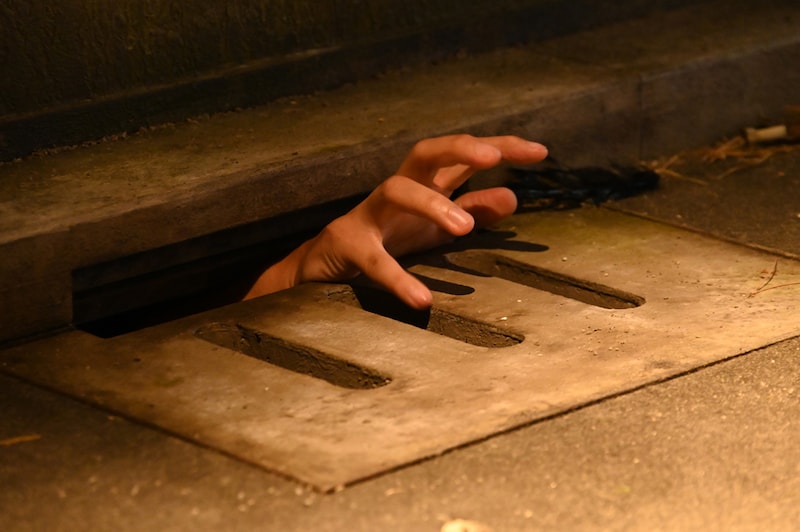 「ホラーにふれる展 －映画美術の世界－」に用意されたフォトスポット。排水溝から手を出すことができる