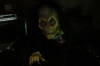 「ホラーにふれる展 －映画美術の世界－」に設置された「空室に住み着いた男」コーナー。“座ったまま事切れた男”が展示されている