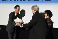 第17回TAMA映画賞で最優秀男優賞を受賞した長塚京三（左）にサプライズでお祝いの花束を渡す豆原一成（中央）