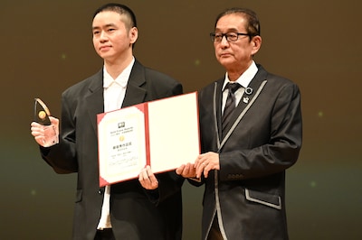 第10回ゴールドクレイン賞（金鶴賞）授賞式の様子。左からジャッキー・ガン（甘剣宇）とプレゼンターの滝田洋二郎