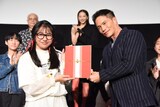 藤戸野絵（左）から寄せ書きを受け取る市原隼人（右）