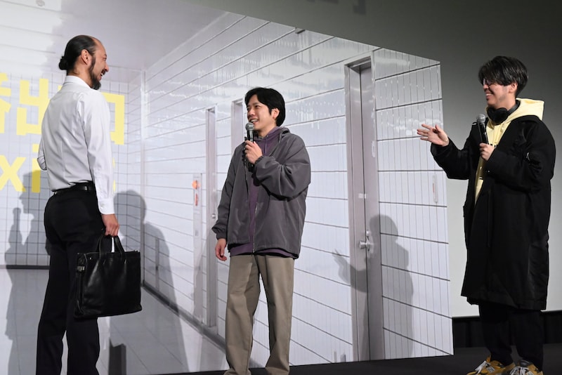 “振り返ったら歩く男が笑っている”シーンの撮影を再現する河内大和（左）、二宮和也（中央）、川村元気（右）