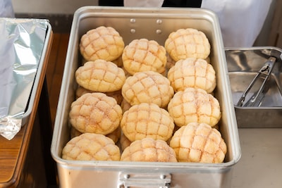 「おいしい給食 炎の修学旅行」より、箱に並べられたメロンパン。それを見た甘利田は「メロンてんこ盛り～！」と心の声を発する