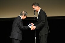 トロフィーを受け取る長塚京三（右）