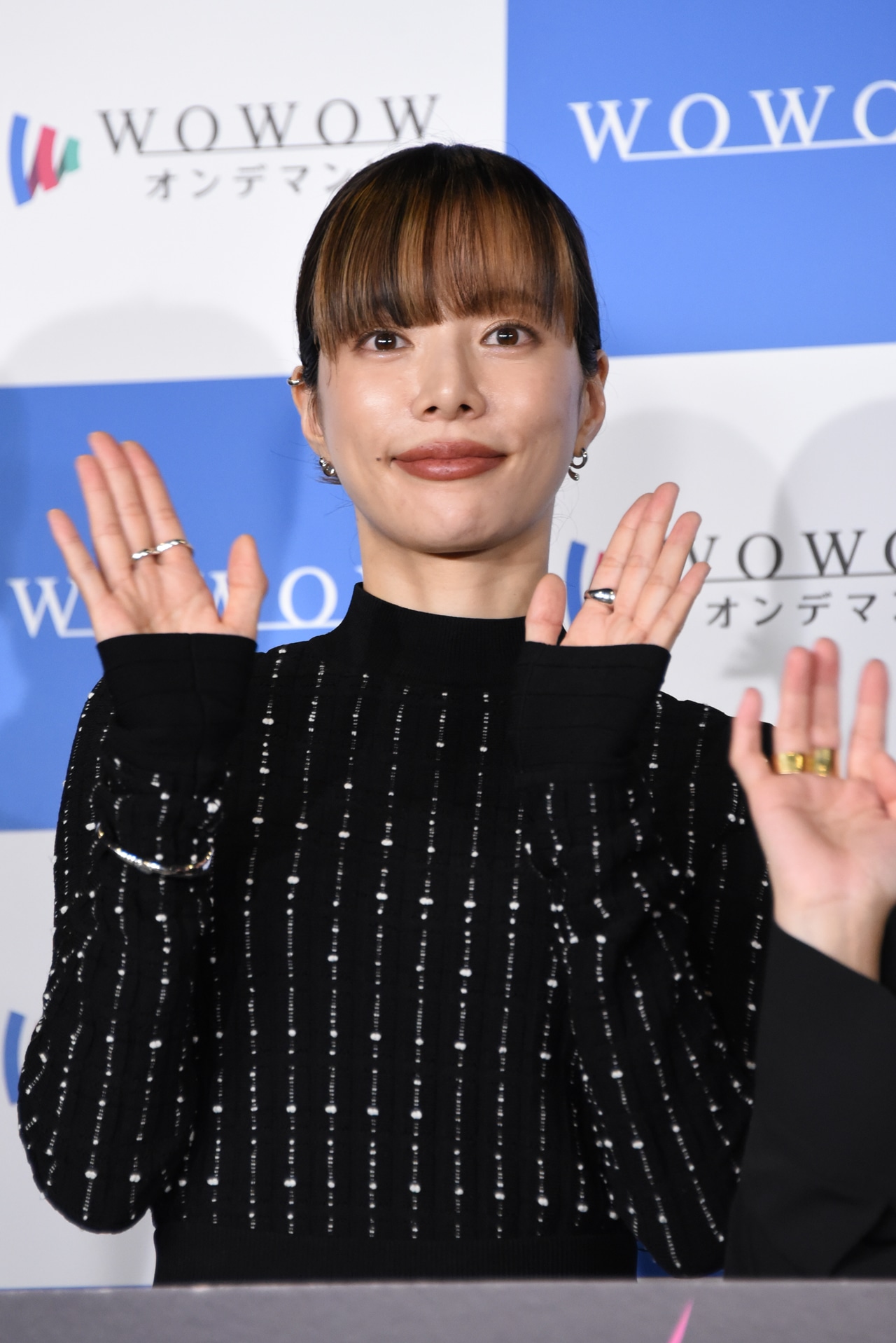 「連続ドラマＷ シャドウワーク」完成報告会の様子。手の動きにバリエーションを付けながらムービーカメラに手を振る桜井ユキ