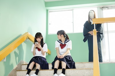 「とれ！」場面写真。地元の廃墟を訪れて以来、美咲は和装でお面のような顔の“神様”に憑きまとわれることになる