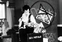 来場者に先着で贈られるオリジナルポストカード表面イメージ。ゲイリー・オールドマン演じるシド・ヴィシャスがベースを弾く姿がデザインされた