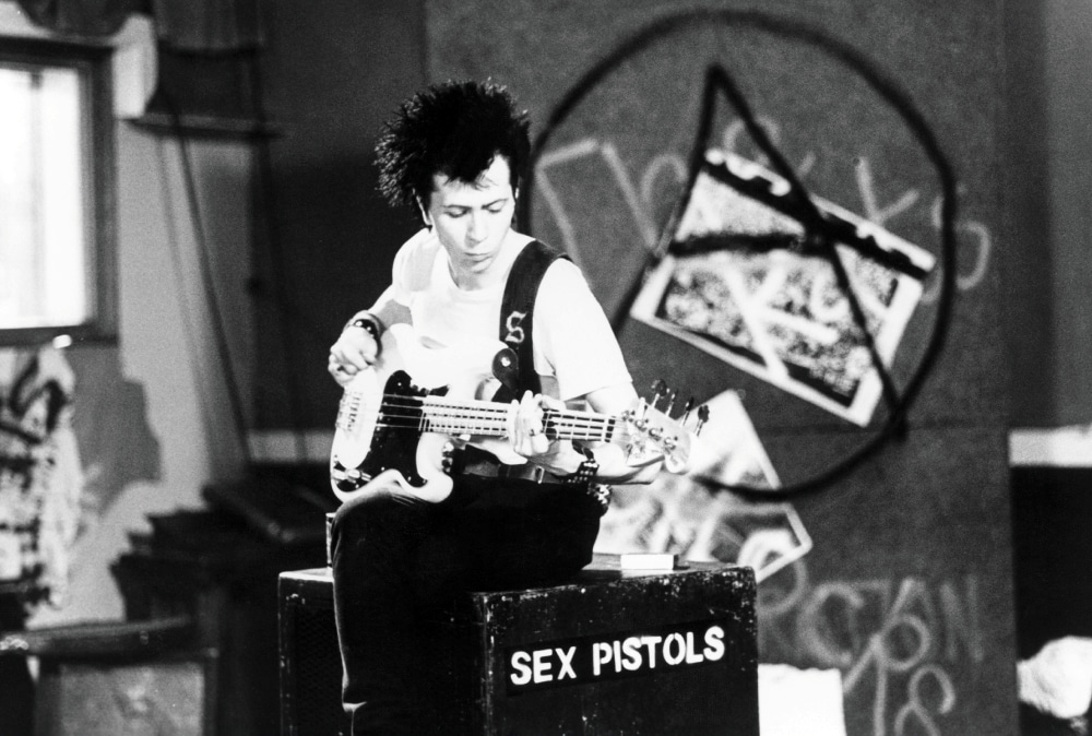 来場者に先着で贈られるオリジナルポストカード表面イメージ。ゲイリー・オールドマン演じるシド・ヴィシャスがベースを弾く姿がデザインされた