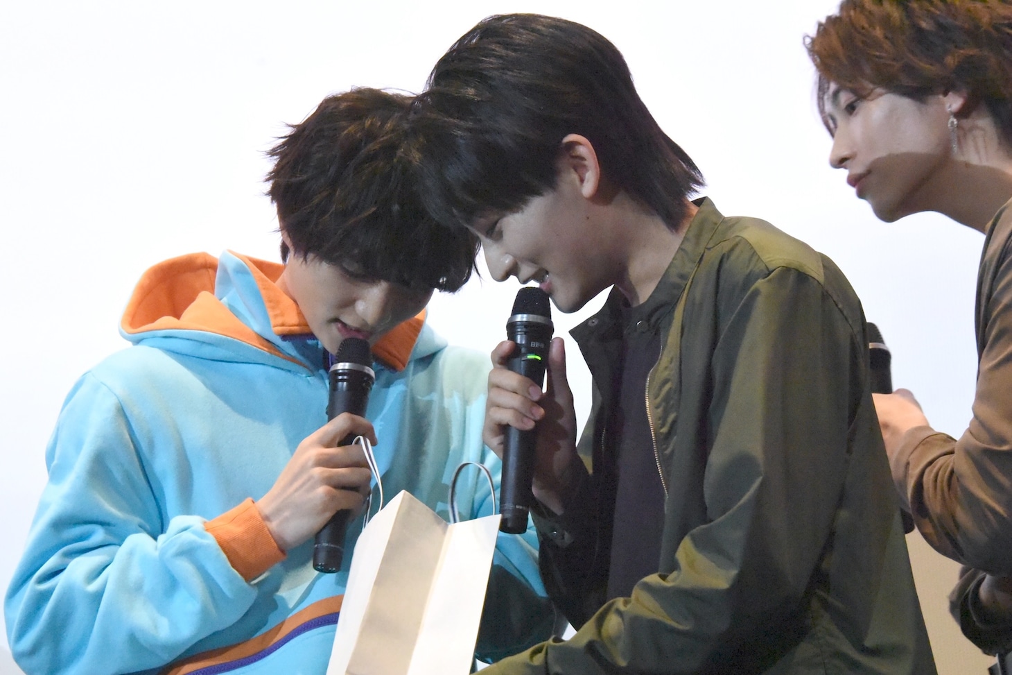 靴下の入った紙袋の中を覗き込む知念英和（左）、日野友輔（中央）、（右）