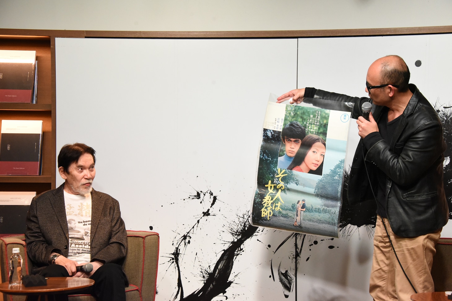 井上由一（右）は75歳の誕生日を迎えた三船史郎（左）に映画「その人は女教師」」のポスターをプレゼントした