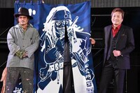 平田広明（右）はジョニー・デップ（左）に、尾田栄一郎によるジャック・スパロウのイラストが描かれた暖簾をプレゼントした
