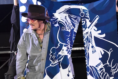 ジャック・スパロウが描かれた暖簾をくぐるジョニー・デップ