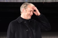 髪をかき上げようとするマッツ・ミケルセン