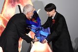 「アバター：ファイヤー・アンド・アッシュ」来日ジャパンプレミアより、宮世琉弥（右）から花束を受け取るジェームズ・キャメロン（左）