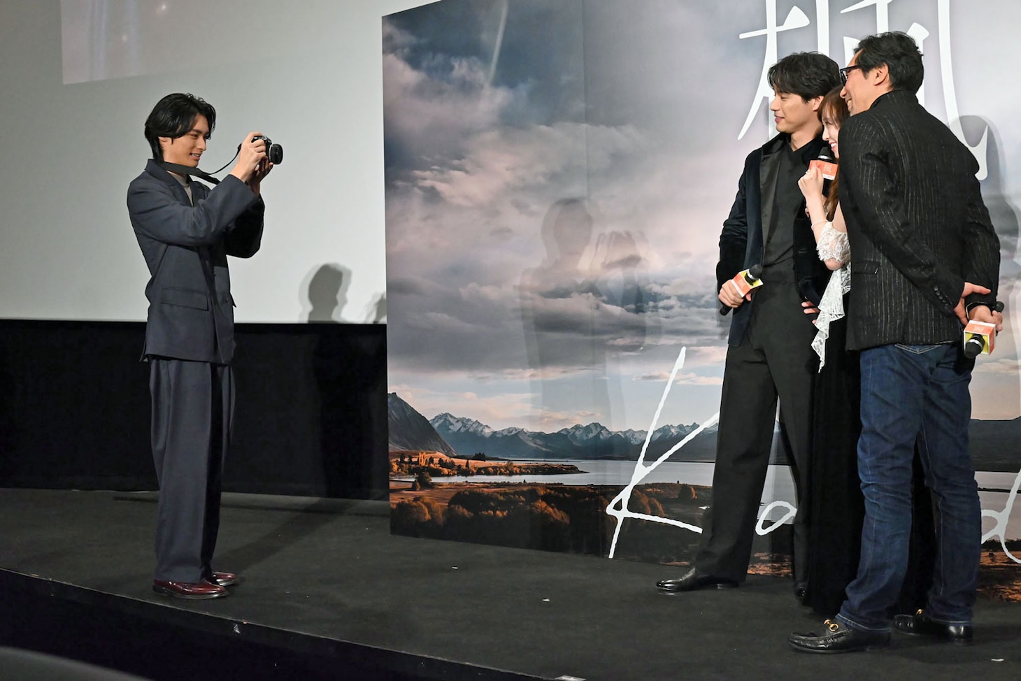 登壇者たちを記念撮影する北島岬（左）