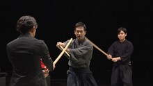 「明鏡止水 武のKAMIWAZA」第4回「驚異の回転！スノーボード・ハーフパイプ」より、岡田准一（左）と木刀を交える是風会・髙無宝良（中央）