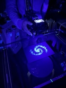 粉状のパステルを黒い紙に塗ったものをブラックライトで照らして宇宙の光を表現した