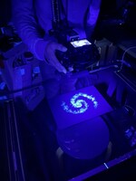 粉状のパステルを黒い紙に塗ったものをブラックライトで照らして宇宙の光を表現した