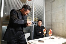 東京・原宿のINITIAL表参道でパフェに銃口を向ける山口祥行（左）