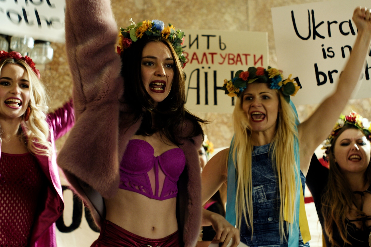 「OXANA／裸の革命家・オクサナ」場面写真。花冠を被り仲間たちと抗議活動を行うオクサナ
