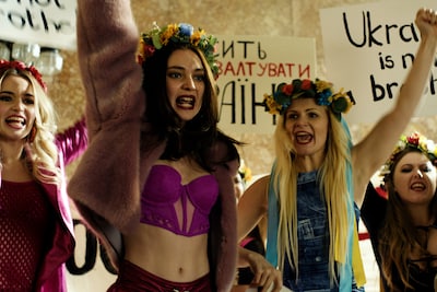 「OXANA／裸の革命家・オクサナ」場面写真。花冠を被り仲間たちと抗議活動を行うオクサナ