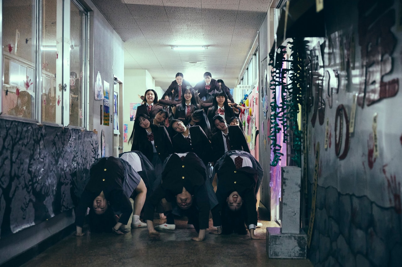 「NEW GROUP」場面写真。学校の廊下に突如現れた、組体操の集団