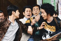 映画「TOKYO BURST-犯罪都市-」新場面写真。新宿中央署の前でもみ合う面々。水上恒司演じる破天荒な新人刑事の相葉四郎（右）と、ユンホ演じる韓国警察庁のエリート刑事チェ・シウ（左）