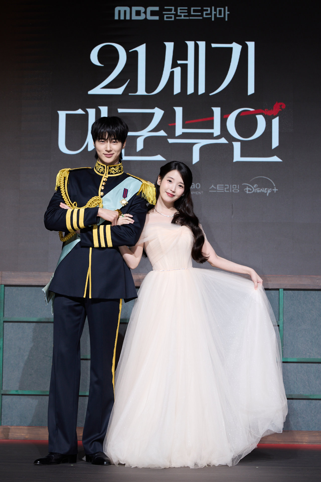 韓国ドラマシリーズ「21世紀の大君夫人」会見の様子。華やかな衣装をまとったIU（右）とビョン・ウソク（左）