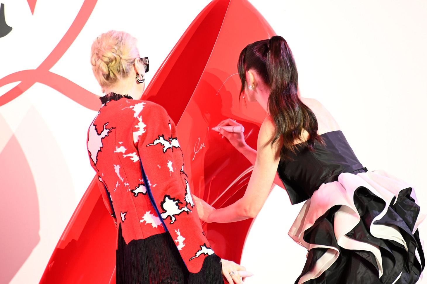 「プラダを着た悪魔2」来日スペシャルイベントの様子。巨大ハイヒールにサインするメリル・ストリープ（左）、アン・ハサウェイ（右）